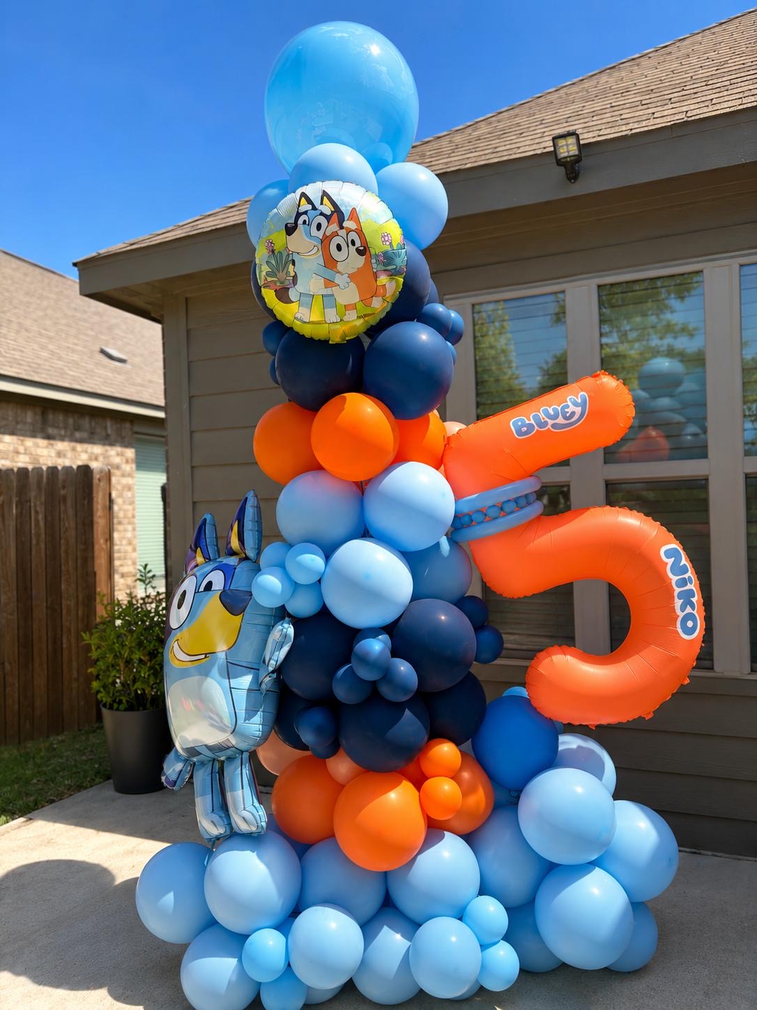 Tall blue and orange character birthday balloon column