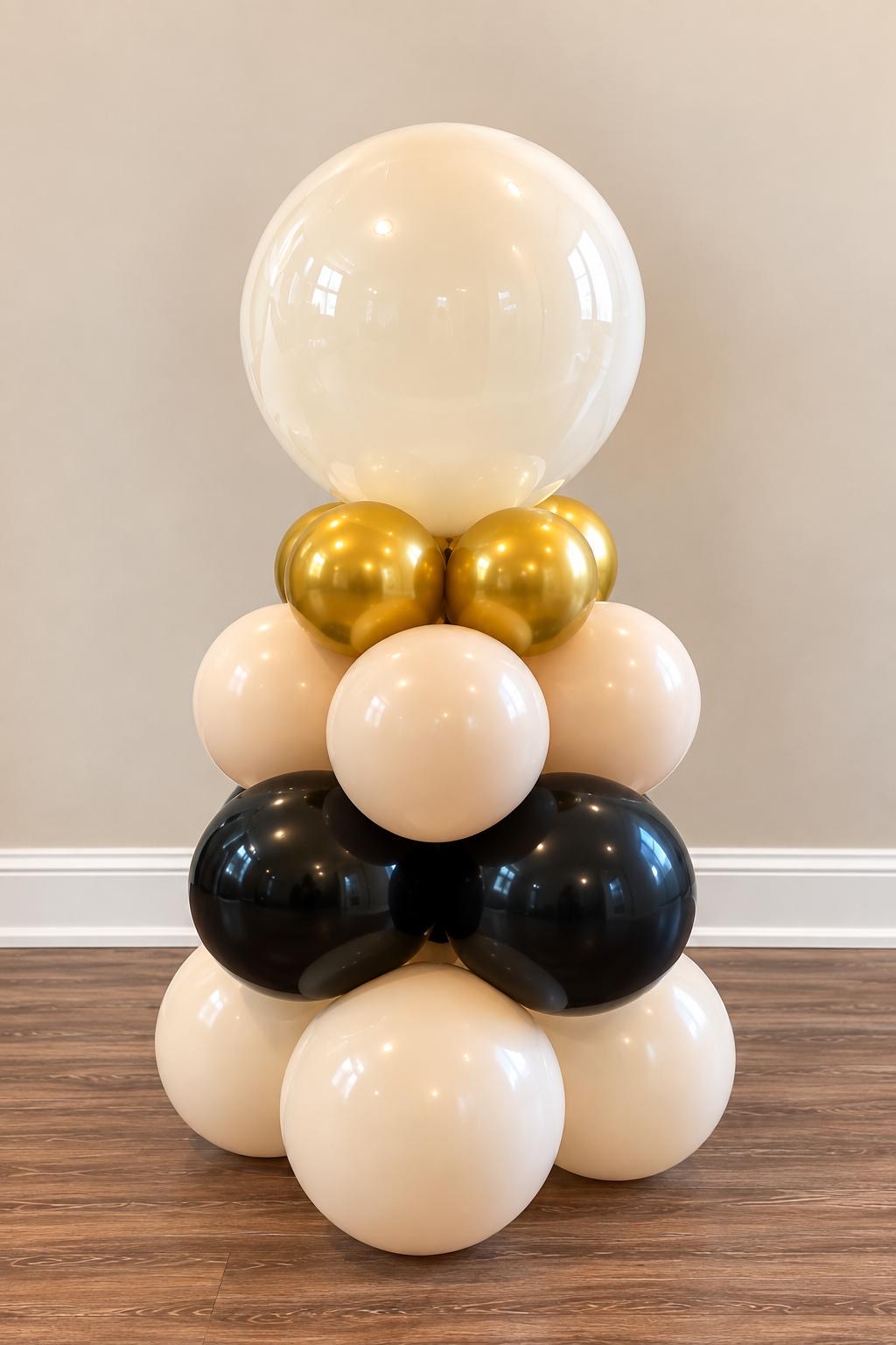 Cream, gold and black balloon column with a clear bubble topper