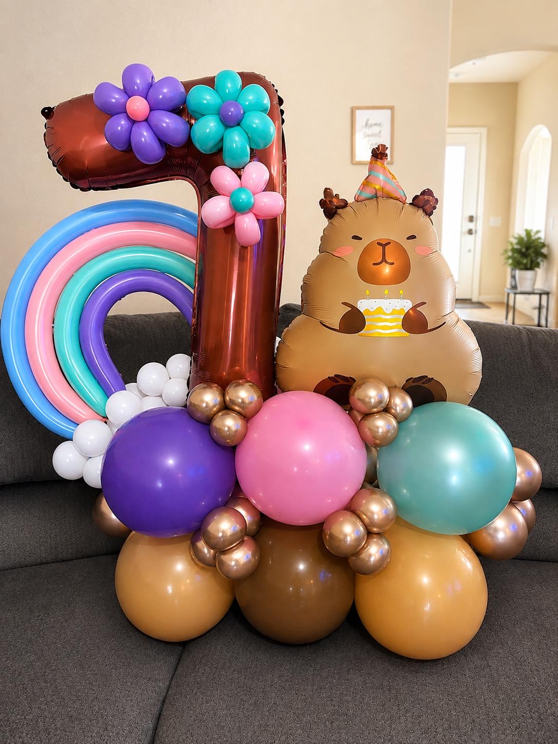 Pastel first birthday balloon stack with a number one and a rainbow
