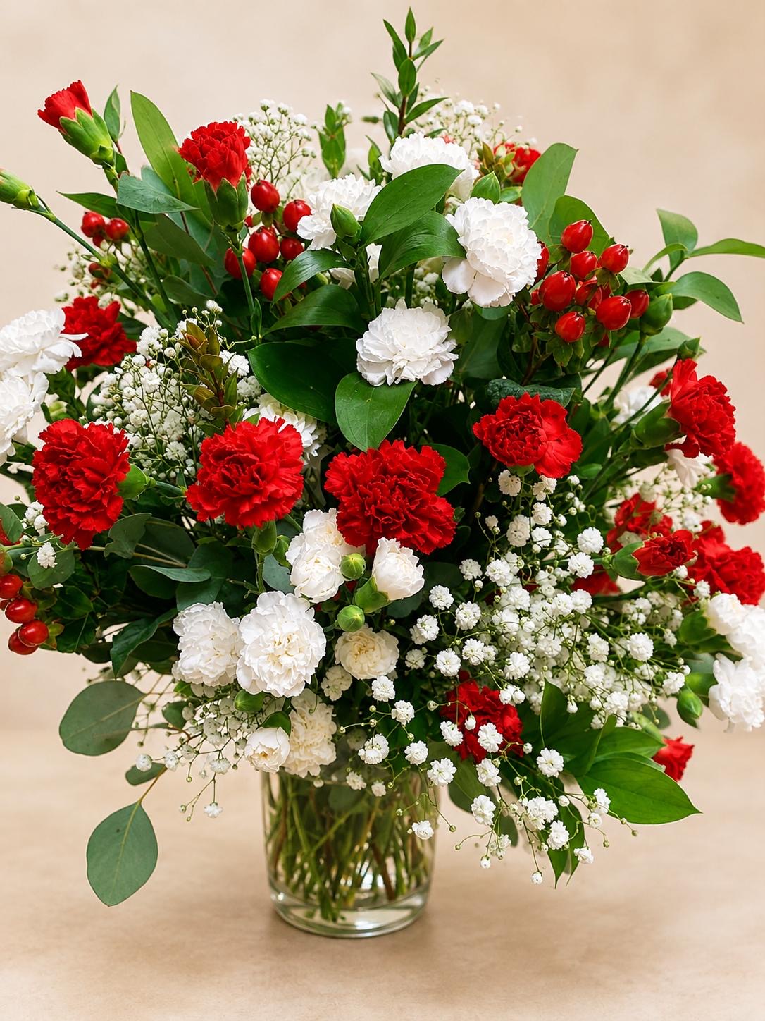 Red and white carnation arrangement in a glass vase