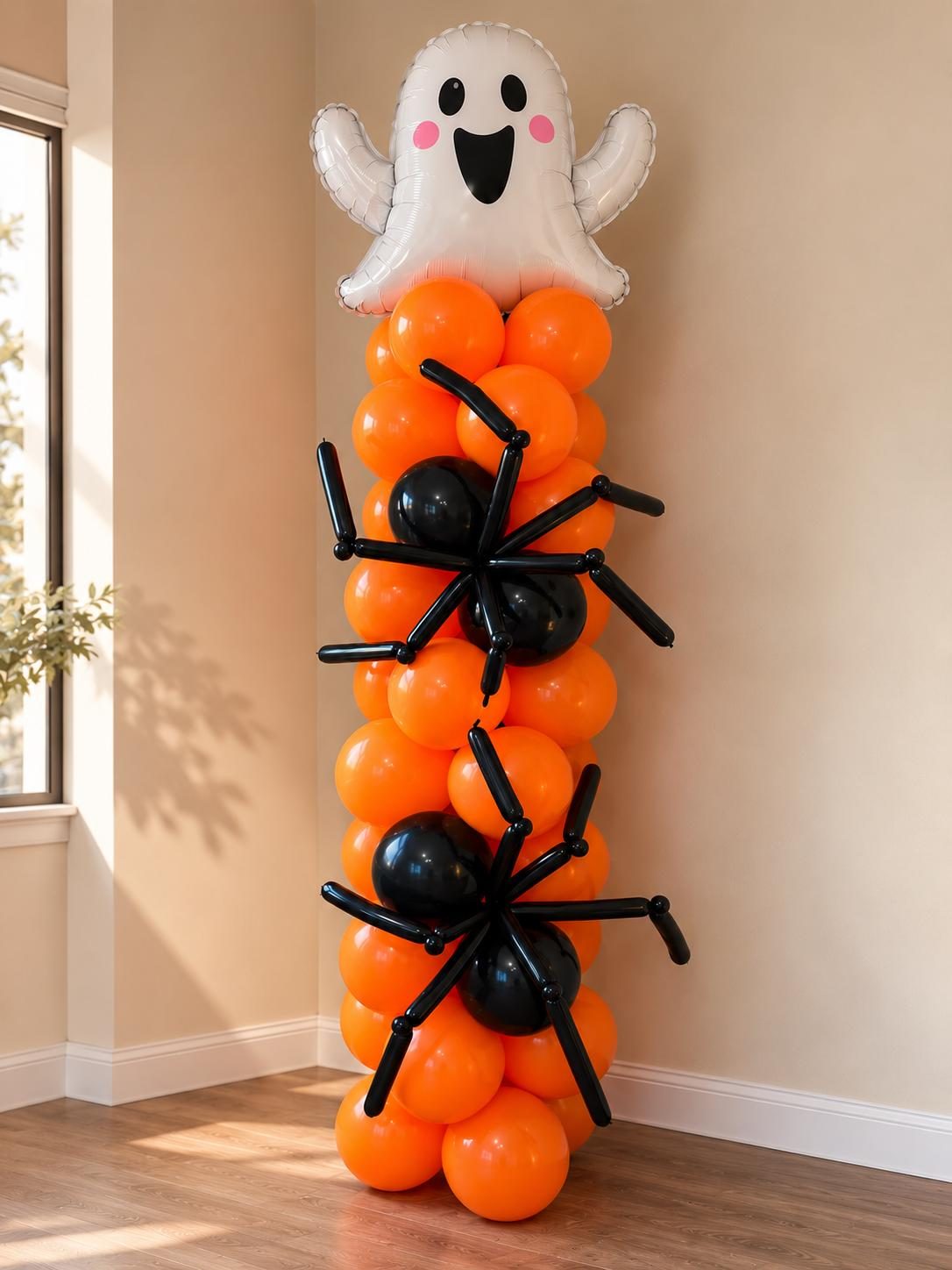 Estructura de globos naranja envuelta con arañas de globos negros y un fantasma en la punta