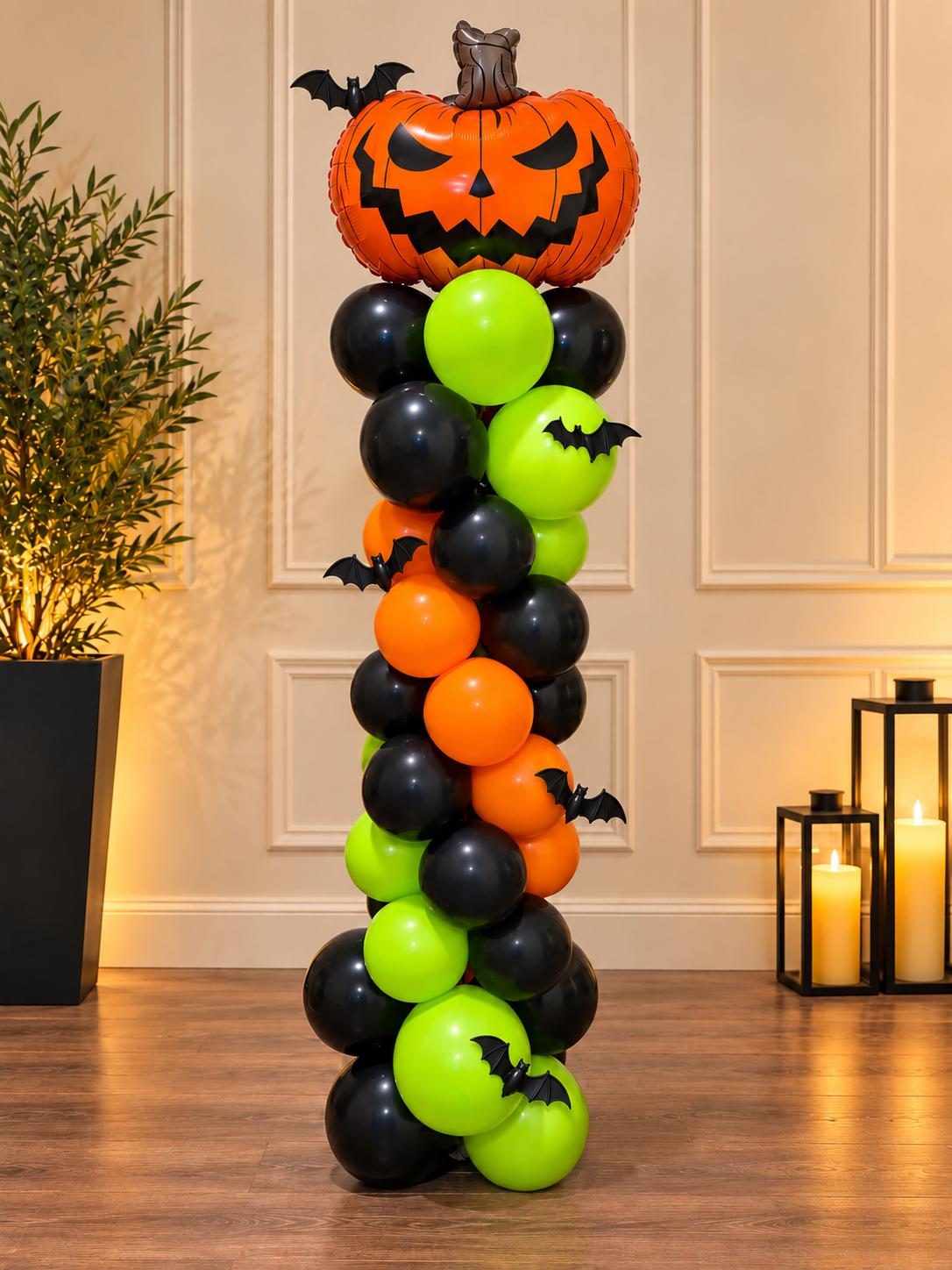 Estructura de globos en espiral para Halloween en verde, naranja y negro con una calabaza en la punta