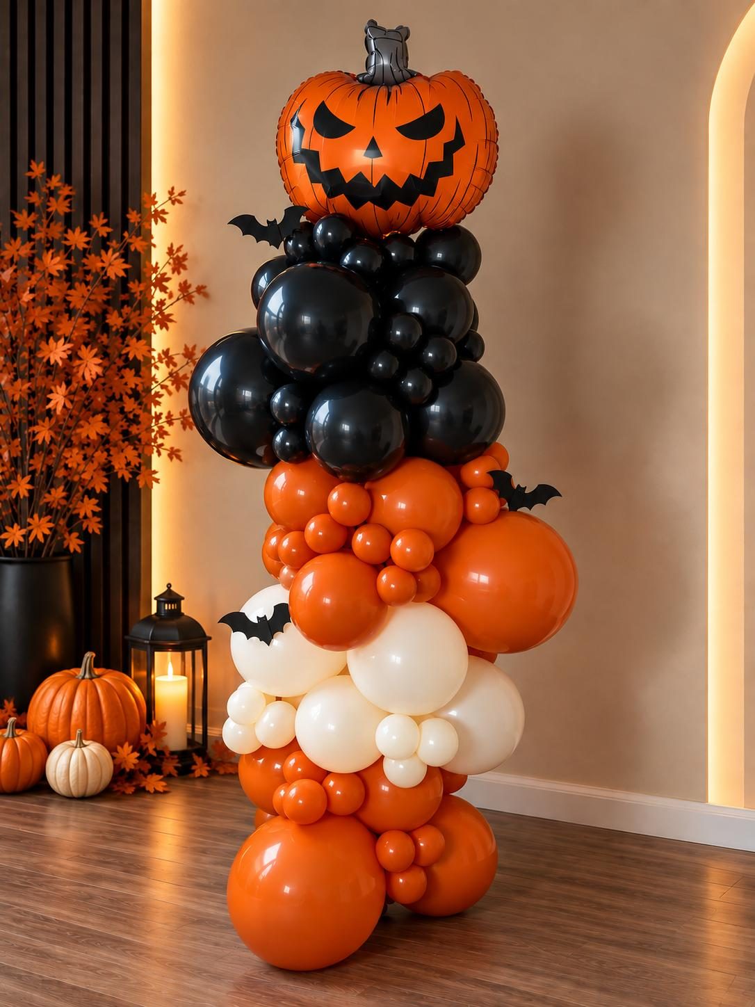 Estructura de globos estilo orgánico en negro, naranja y blanco con una calabaza en la punta