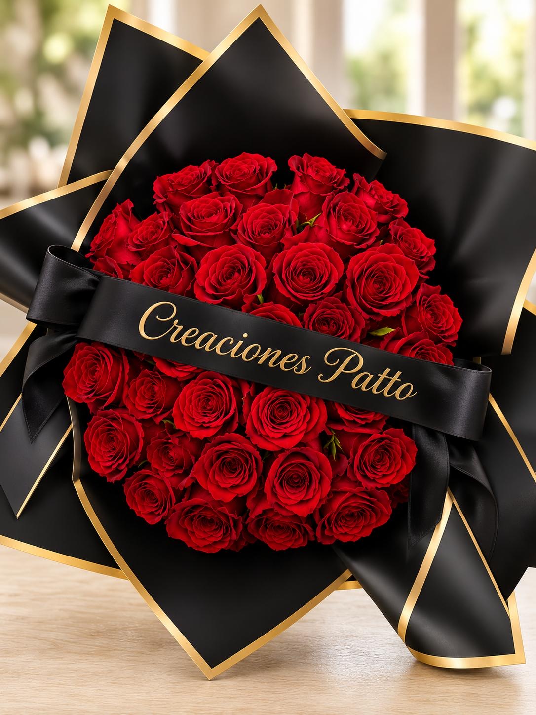 Red rose bouquet in black and gold wrapping with a ribbon sash