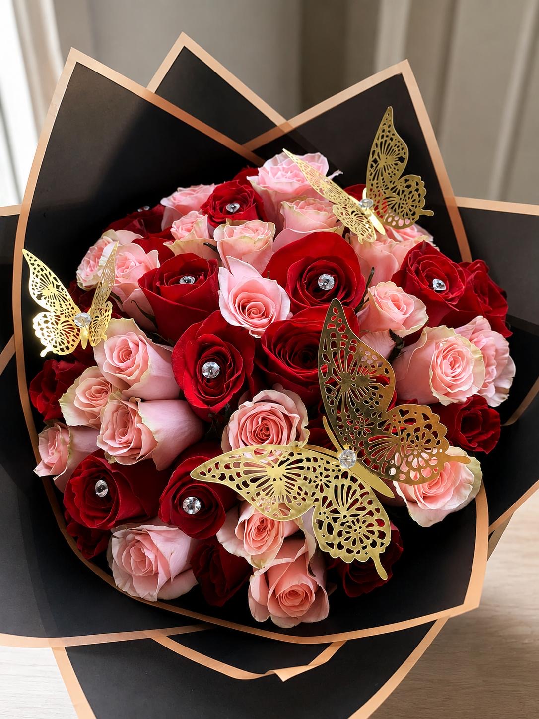 Red and pink rose bouquet with gold butterfly accents