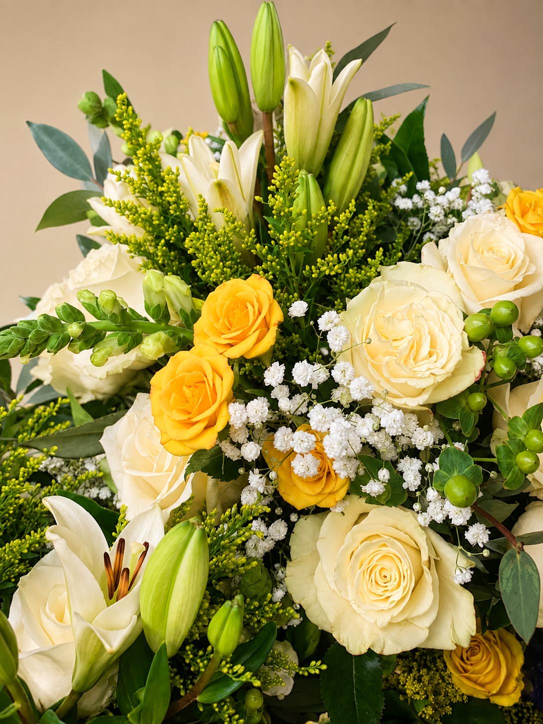 Arrangement of white and yellow roses with lilies