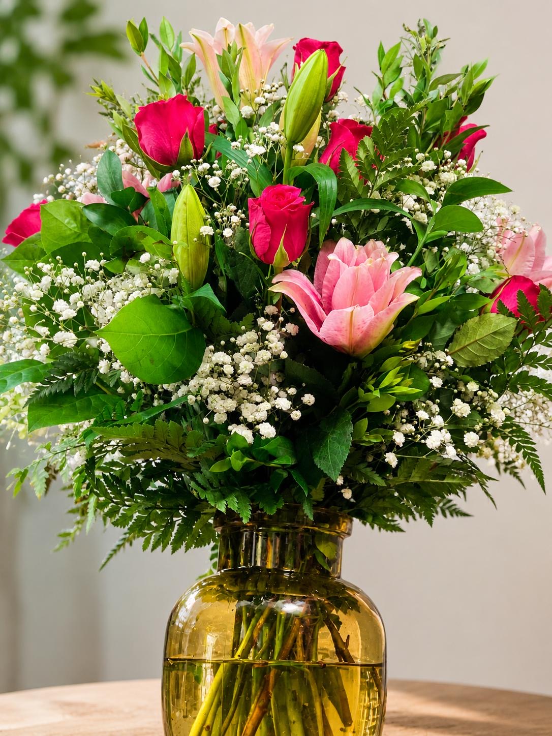 Pink roses and lilies in an amber glass vase
