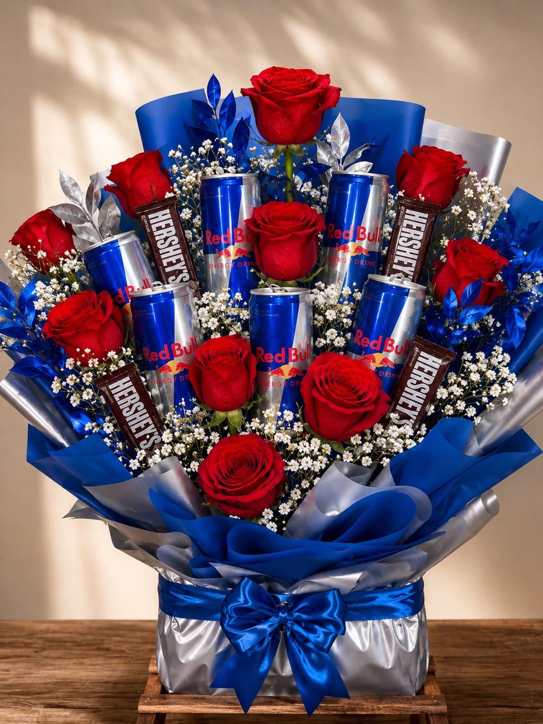 Bouquet of red roses with chocolate bars and drinks in blue wrapping