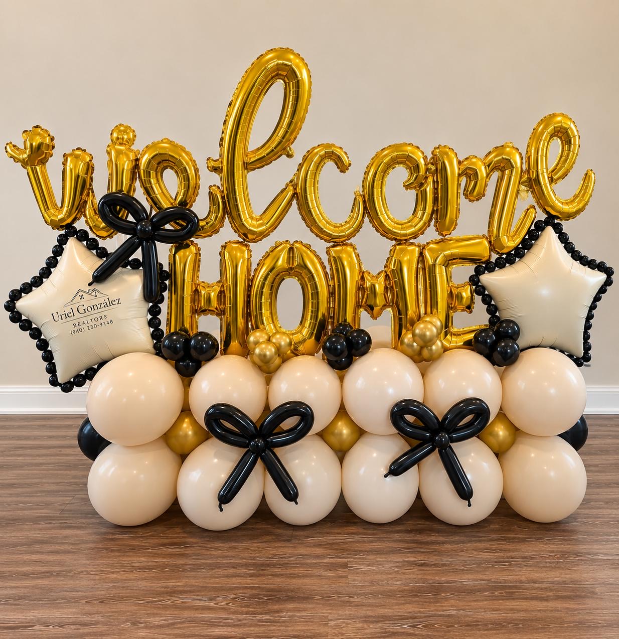 Letras doradas de welcome HOME sobre una base de globos crema, dorados y negros con estrellas personalizadas